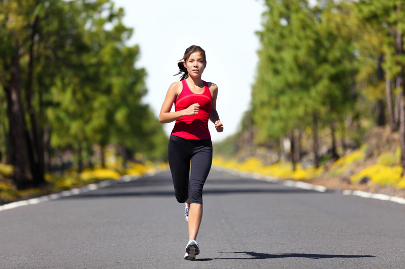Sport fitness running woman jogging during outdoor workout. Beautiful young female athlete runner training for marathon on forest road in spring or summer. Mixed race Asian woman fitness model.; Shutterstock ID 97819907; PO: aol; Job: production; Client: drone