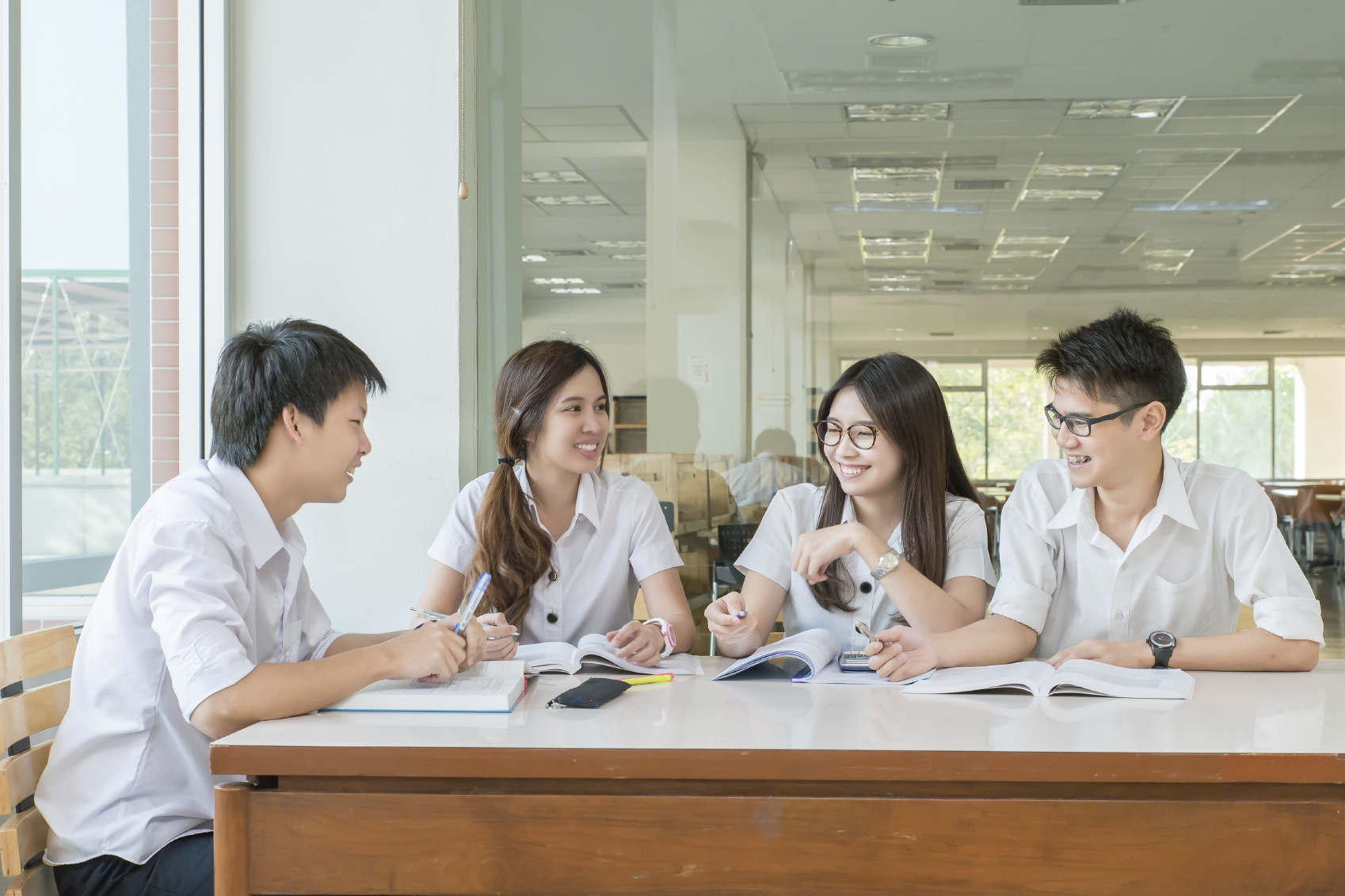 Group of asian students in uniform studying together at classroom