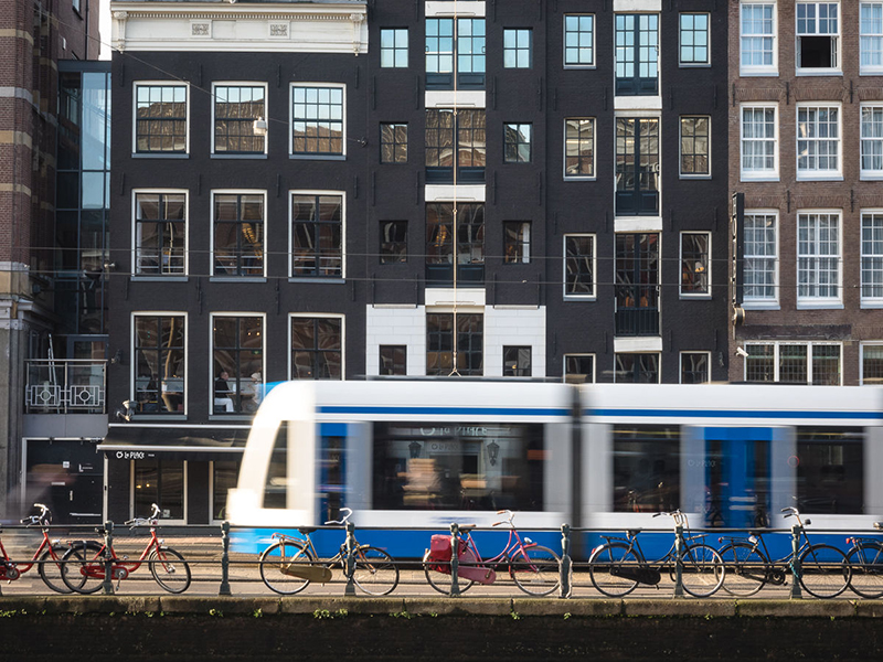 Tram à Amsterdam avec des vélos en avant plan