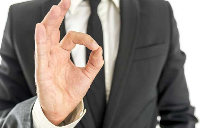 Closeup of satisfied businessman showing an OK gesture.