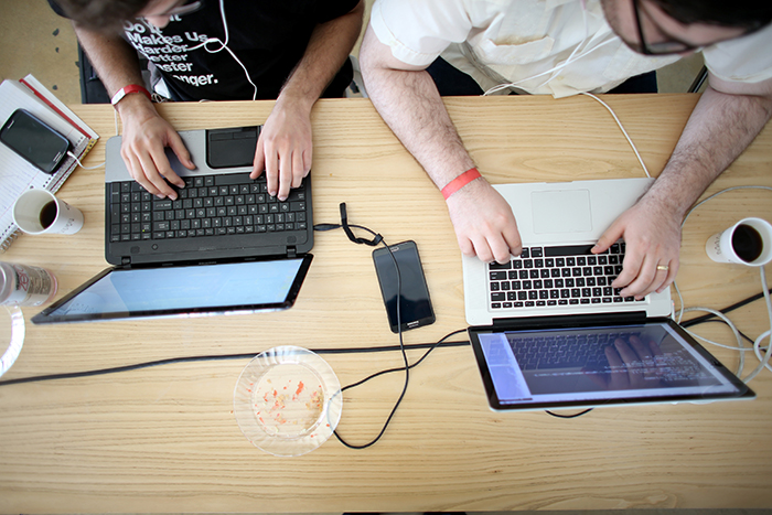 MIAMI, FL - FEBRUARY 01:  Miguel Chateloin  (L) and Lazaro Gamio use their computers to write code that would allow people living in Cuba to use email to post to blogs during the Hackathon for Cuba event on February 1, 2014 in Miami, Florida.  The hackathon brought together experts and programmers to devise innovative technology solutions aimed at strengthening communications and information access in Cuba. The event is organized by Roots of Hope with support from the John S. and James L. Knight Foundation.  (Photo by Joe Raedle/Getty Images)