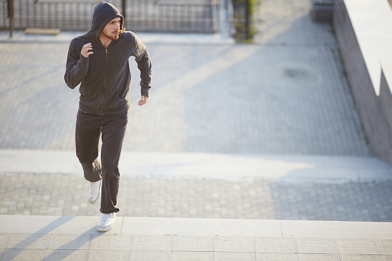 Portrait of young sportsman jogging outside