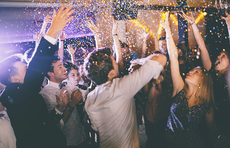 Group of people throwing confetti into the air in celebration at a party