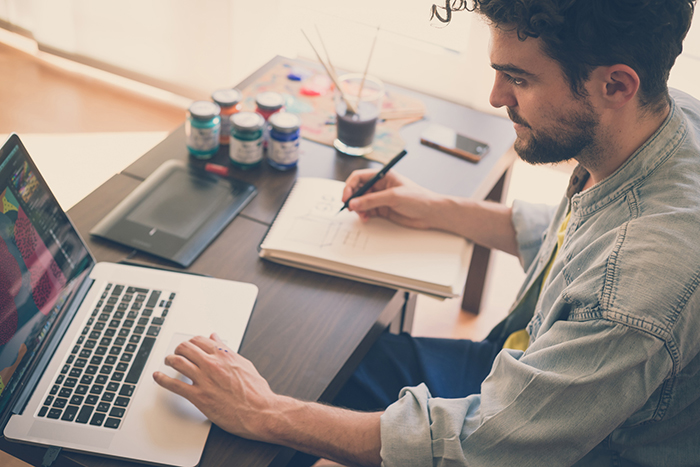 handsome hipster modern man designer working home using laptop at home