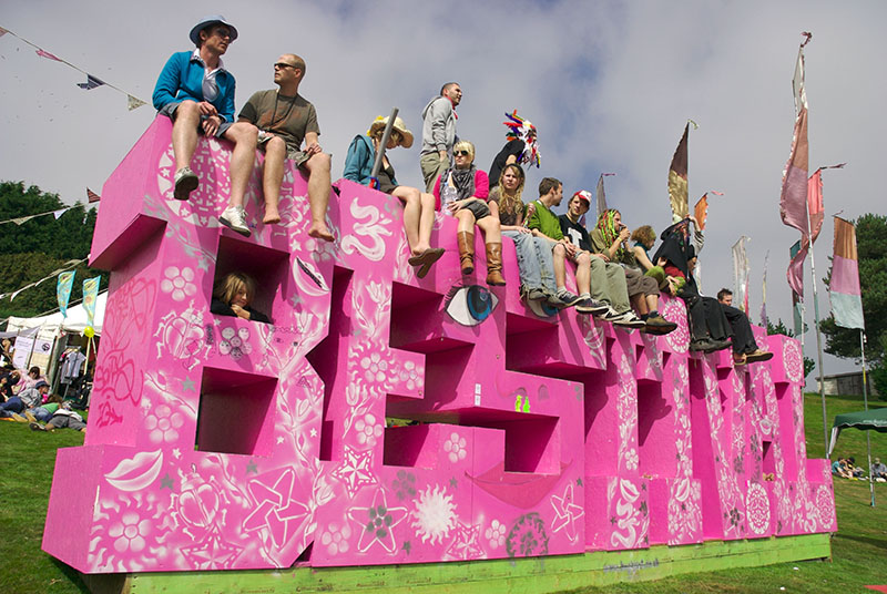 Mandatory Credit: Photo by James Lange / PYMCA / Rex Features ( 935440a ) People sat on a Bestival sign. Bestival 2007  Isle of Wight STOCK