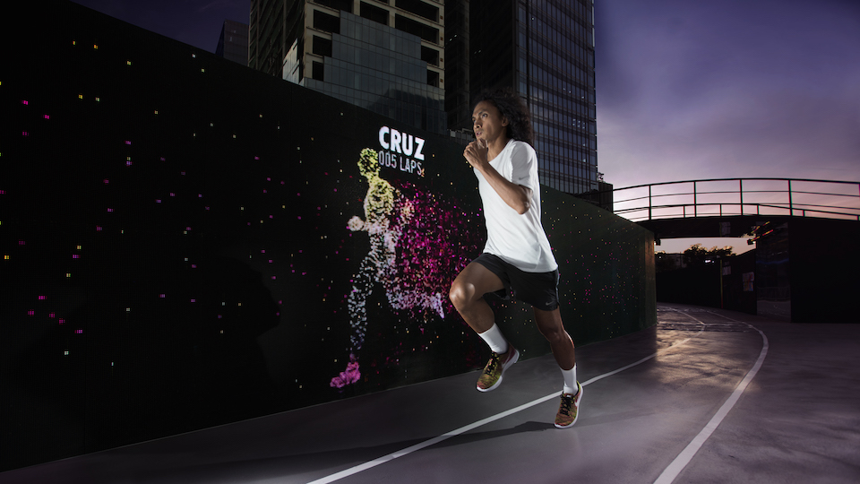 Nike Run Club Coach Rio dela Cruz outpacing his avatar at the Unlimited Stadium