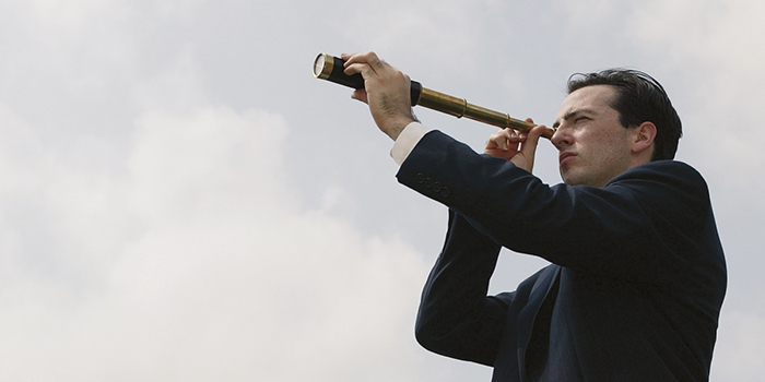 Businessman looking through spyglass